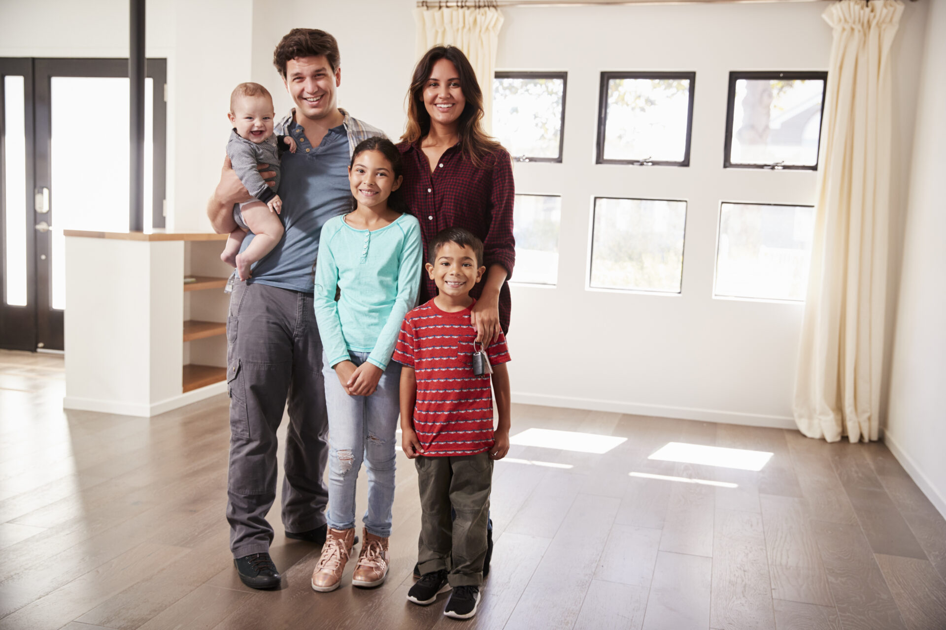 Portrait of happy family with baby who got a loan with FMS's USDA Home Loans